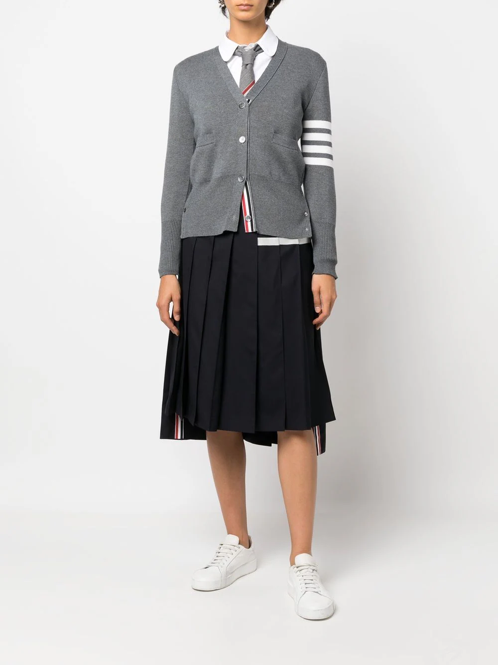 Thom Browne navy twill pleated midi skirt with four white grosgrain bar stripes at the hip and tricolour brand tab at the hem, shown on a white background
