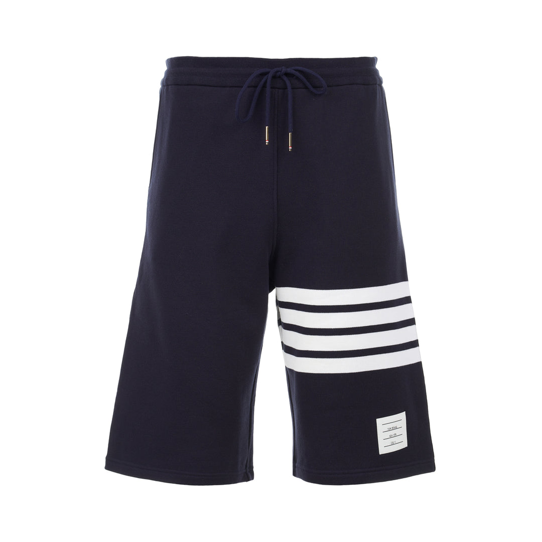 Thom Browne navy cotton sweat shorts with drawstring waist, white 4-Bar stripe on one leg and woven label patch at the hem