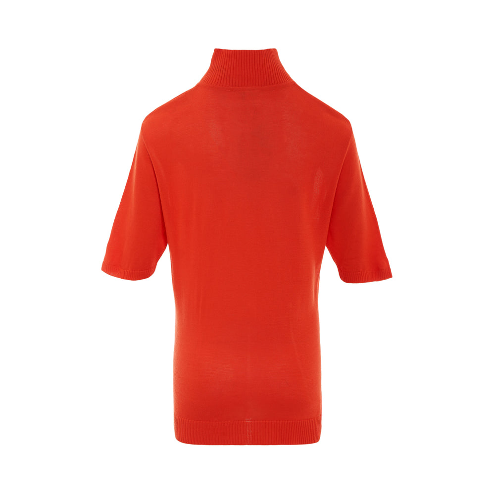 Rally Movement Polo Crew Quarter Zip short-sleeve knit top in red-orange with ribbed mock neck, silver zipper pull, and embroidered RM monogram