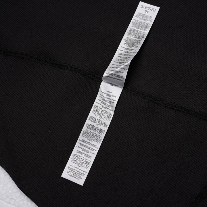 rag & bone Essential Rib Muscle Tank in black, featuring a high racer neckline, fine ribbed knit fabric, and a form-fitting sleeveless silhouette, shown on a flat lay against a white background