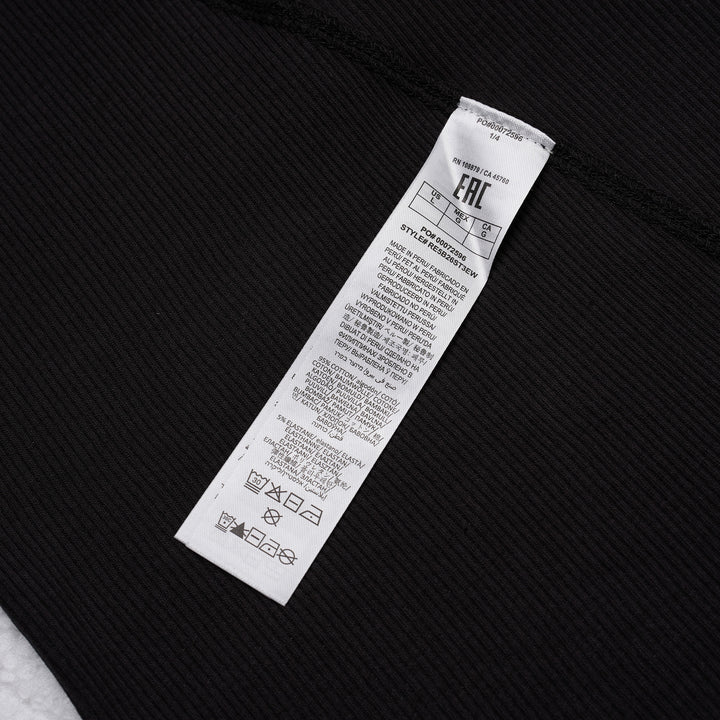 rag & bone Essential Rib Muscle Tank in black, featuring a high racer neckline, fine ribbed knit fabric, and a form-fitting sleeveless silhouette, shown on a flat lay against a white background