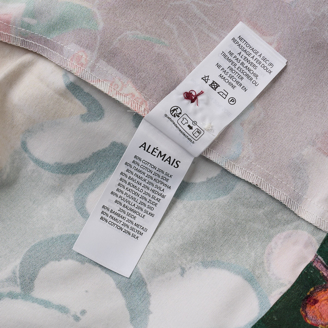 Alemais Tangible Love short-sleeve shirt with patchwork hand-painted panels featuring crocodile, floral, and abstract motifs, oversized hem pockets, and contrast stripe trim on a white background