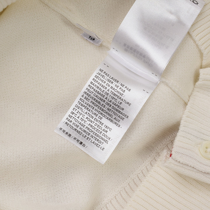 Thom Browne white short sleeve knit polo with red and white striped collar, signature red, white, and blue stripe on both sleeves, and four-button placket