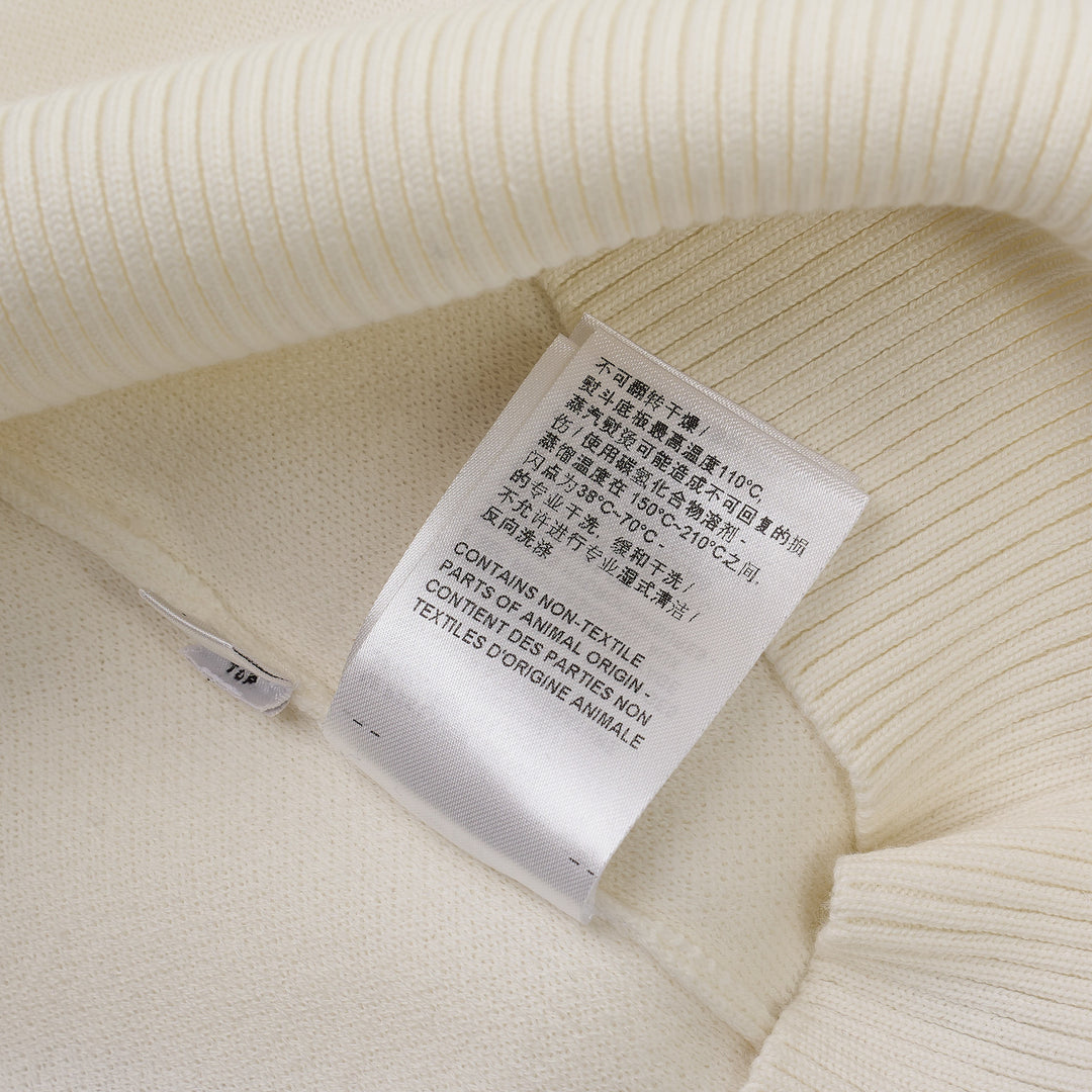 Thom Browne white short sleeve knit polo with red and white striped collar, signature red, white, and blue stripe on both sleeves, and four-button placket