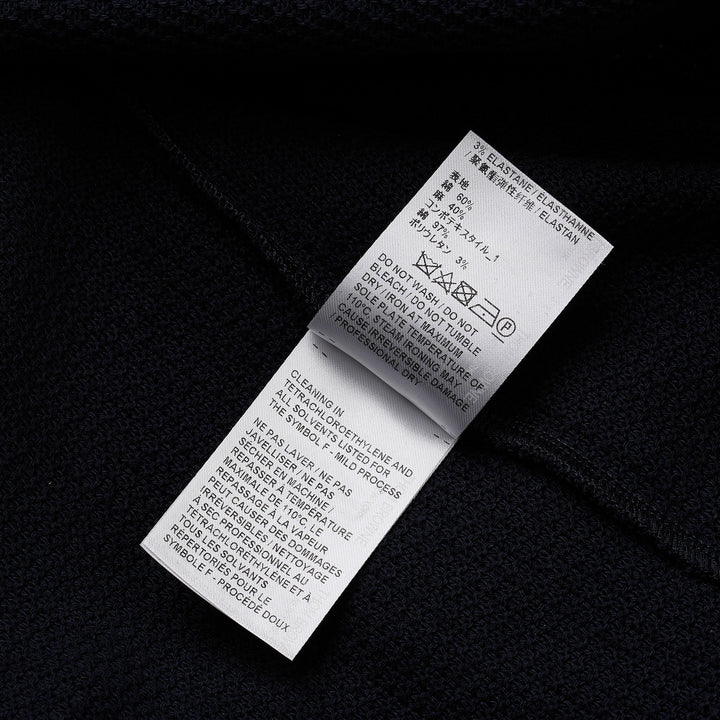Thom Browne navy textured knit relaxed fit short sleeve polo with spread collar, five-button placket, chest pocket, and signature branding tab at the hem