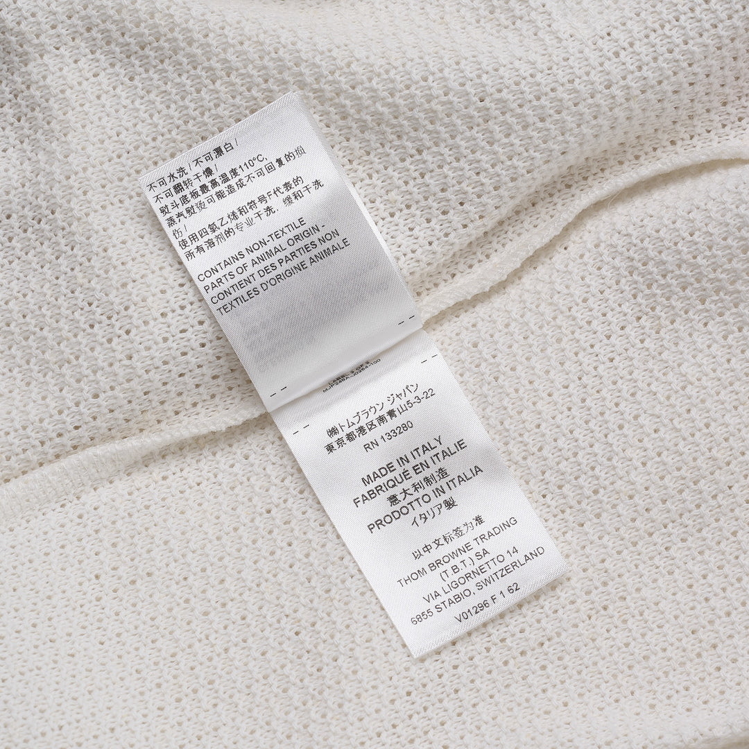 Thom Browne navy textured knit relaxed fit short sleeve polo with spread collar, five-button placket, chest pocket, and signature branding tab at the hem