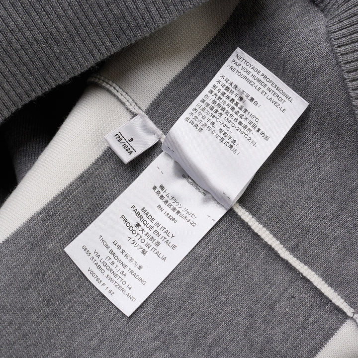 Thom Browne rugby stripe zip-up hoodie in heathered grey and white with signature four-bar stripe on sleeve, full-length zip, drawstring hood, and ribbed hem