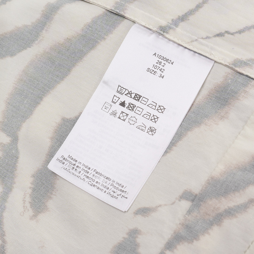 Ganni Printed Stretch Cotton Angel Dress in cream tiger-stripe print with flutter cap sleeves and button neckline, shown flat against a white background