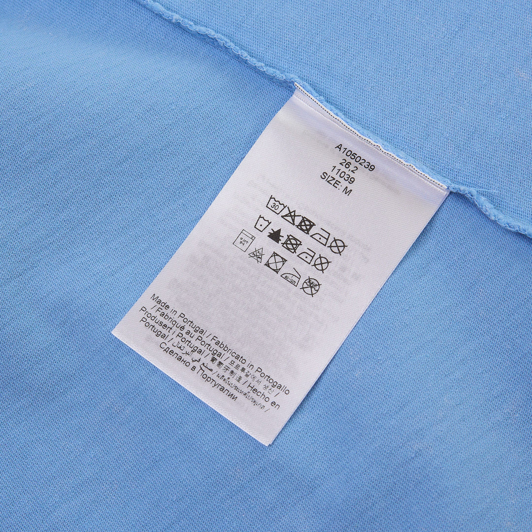 Ganni sky blue baby fit jersey tee featuring a hand-drawn mermaid graphic, Ganni cursive logo print, and 'Have a nice day. Please recycle' slogan on the front