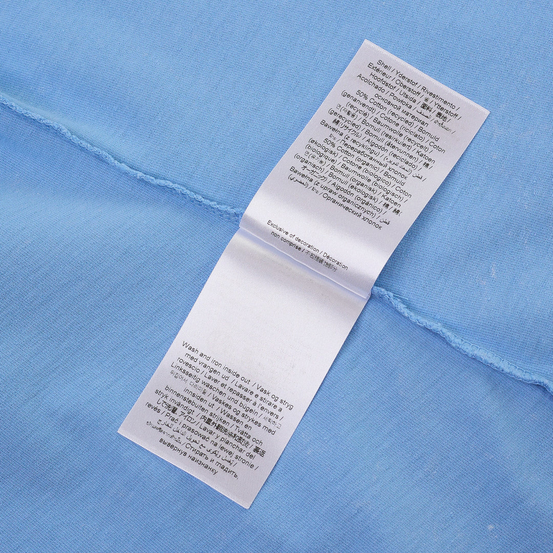 Ganni sky blue baby fit jersey tee featuring a hand-drawn mermaid graphic, Ganni cursive logo print, and 'Have a nice day. Please recycle' slogan on the front