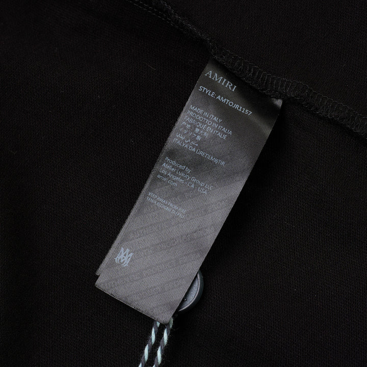 Amiri Arts District Skate Tee in black with tonal embossed chest branding, oversized silhouette and ribbed crewneck, front view