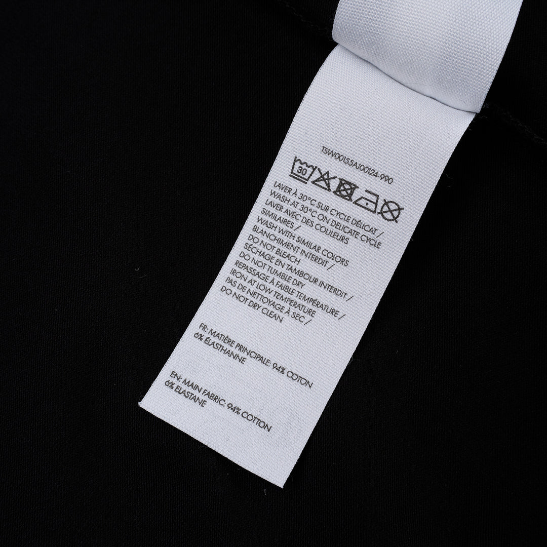 Jacquemus Gros Grain Long Sleeve Tee in black — cropped mock-neck jersey top with tonal grosgrain logo label at the chest, photographed flat on a white background