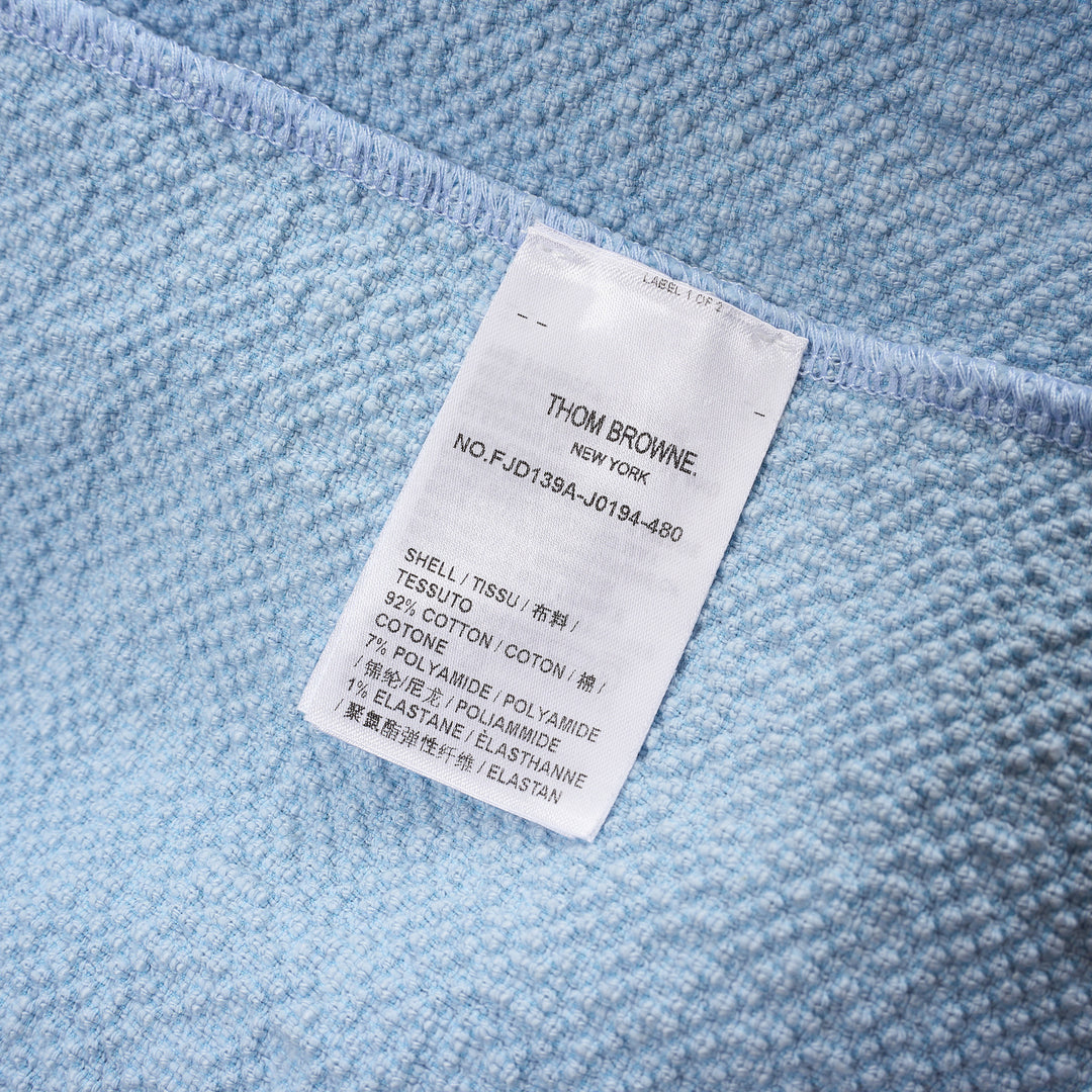 Thom Browne sleeveless polo dress in light blue bouclé with white collar featuring red, white, and blue stripe tipping, button placket, and signature 4-bar stripe at the hem - view 3