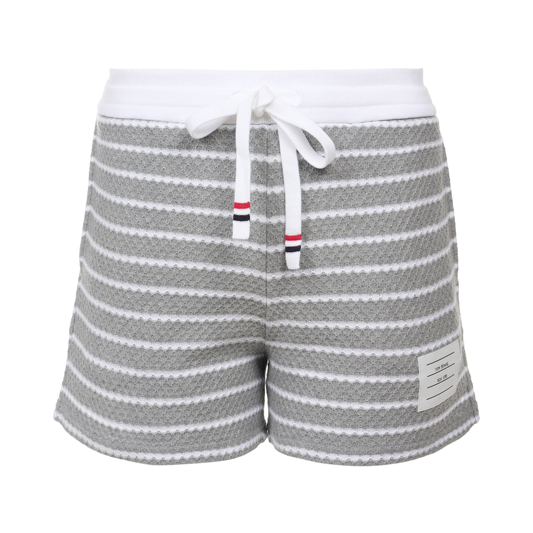Thom Browne grey and white striped honeycomb-textured knit shorts with white ribbed waistband, drawstring tie with stripe detail, and woven brand label at hem