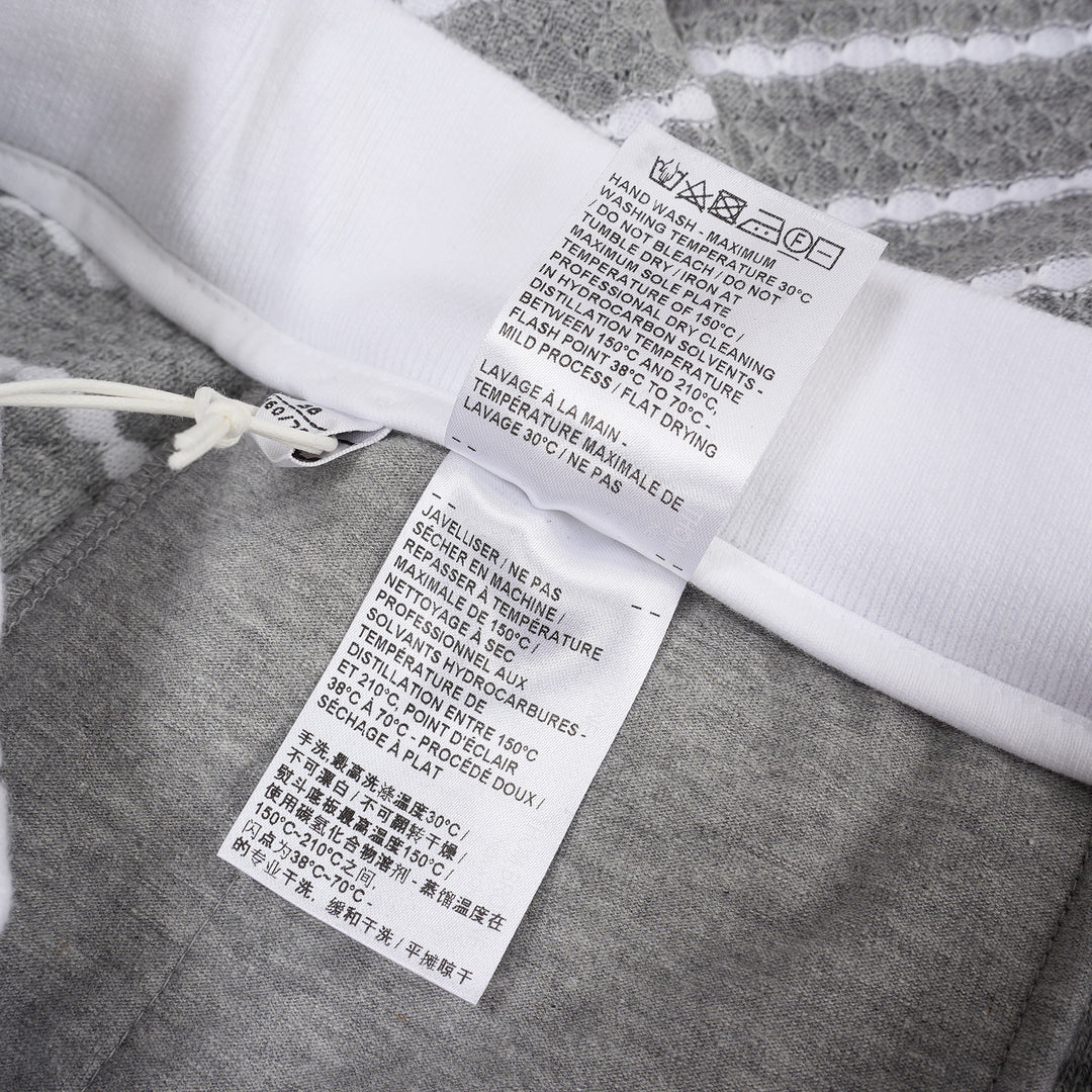 Thom Browne grey and white striped honeycomb-textured knit shorts with white ribbed waistband, drawstring tie with stripe detail, and woven brand label at hem - view 4