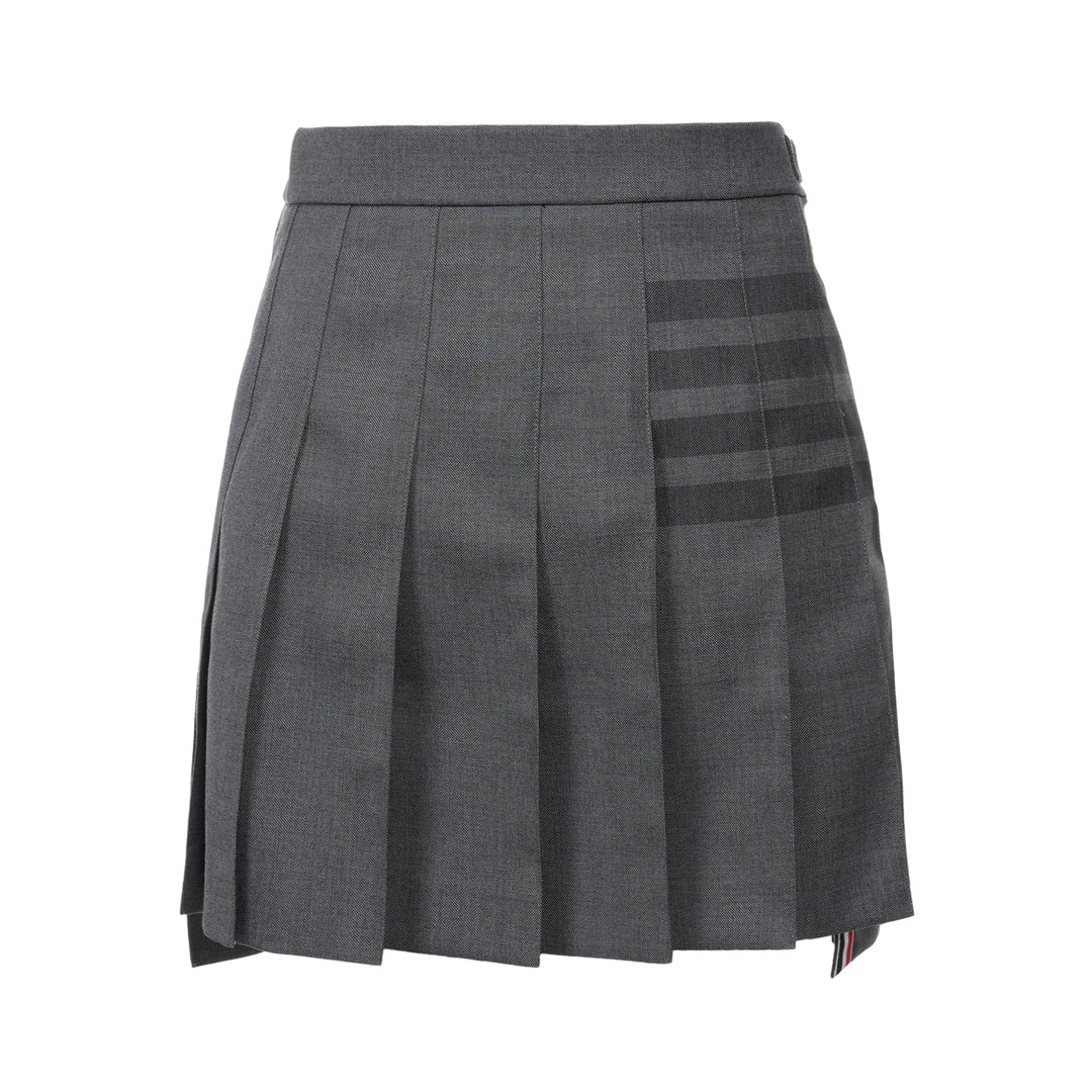 Thom Browne grey pleated mini skirt with tonal 4-bar stripe on one panel and red, white, and blue grosgrain tab at hem