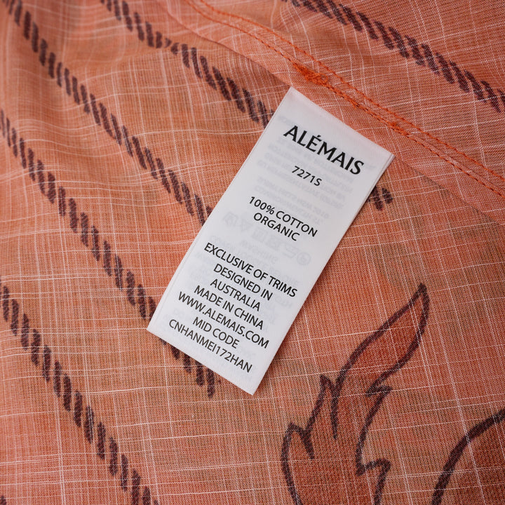 Alemais Boathouse Midi Skirt in orange with tropical beach print featuring palm trees, sun illustration, and floral border hem, displayed on white background