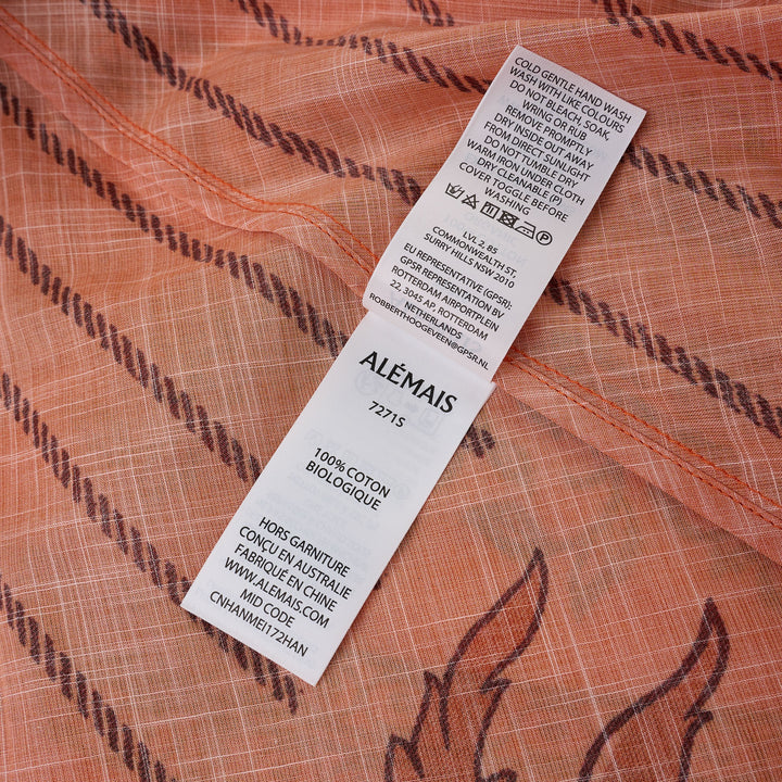Alemais Boathouse Midi Skirt in orange with tropical beach print featuring palm trees, sun illustration, and floral border hem, displayed on white background