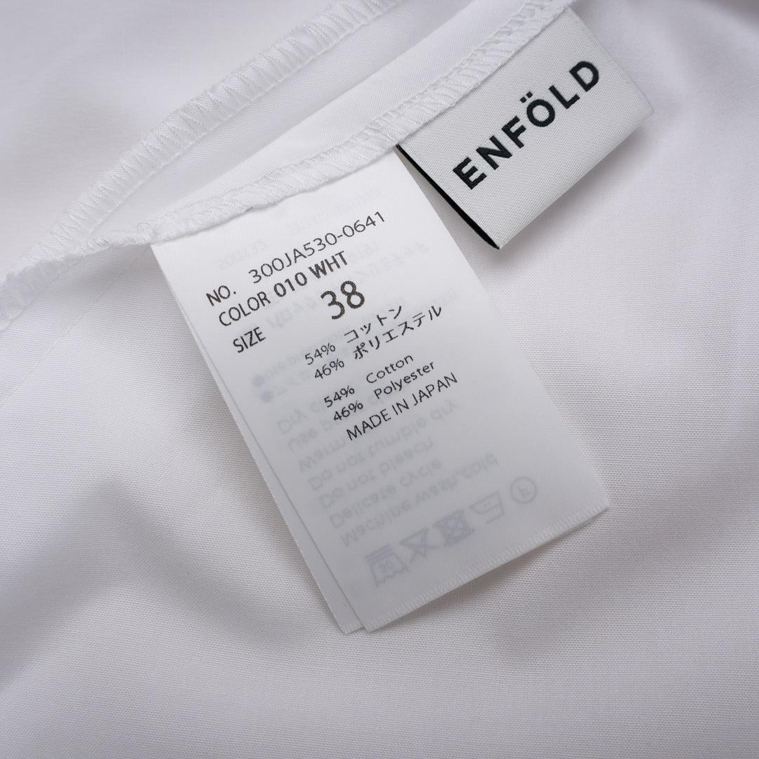 Enfold Big Collar Layered Blouse in white, rear view showing tiered cape collar, voluminous peplum hem, back zip closure, and long self-fabric waist ties