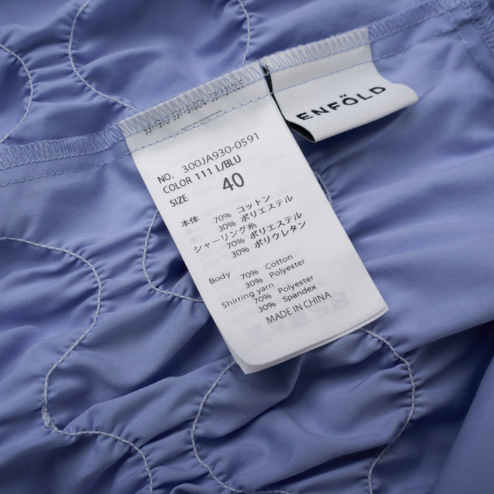 Enfold Shirring Detail Short Sleeve Shirt in periwinkle blue with elasticated smocked waist panel and mother-of-pearl buttons, front view on white background