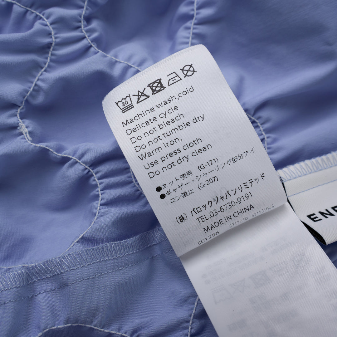 Enfold Shirring Detail Short Sleeve Shirt in periwinkle blue with elasticated smocked waist panel and mother-of-pearl buttons, front view on white background