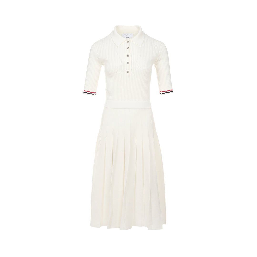 Thom Browne below knee polo dress in ivory ribbed knit with pleated skirt, silver-tone button placket, and signature red, white, and blue stripe cuff trim