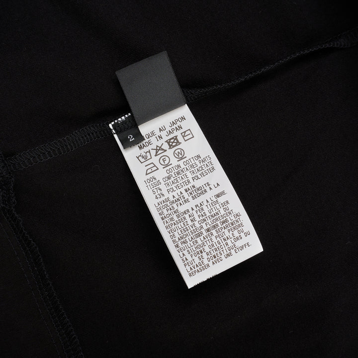 Y's black oversized round neck shirt dress with short folded cuffs, layered T-shirt upper, and buttoned skirt panel, displayed on white background - view 3