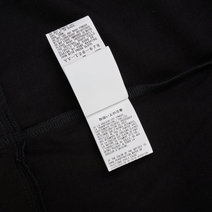 Y's black oversized round neck shirt dress with short folded cuffs, layered T-shirt upper, and buttoned skirt panel, displayed on white background - view 5