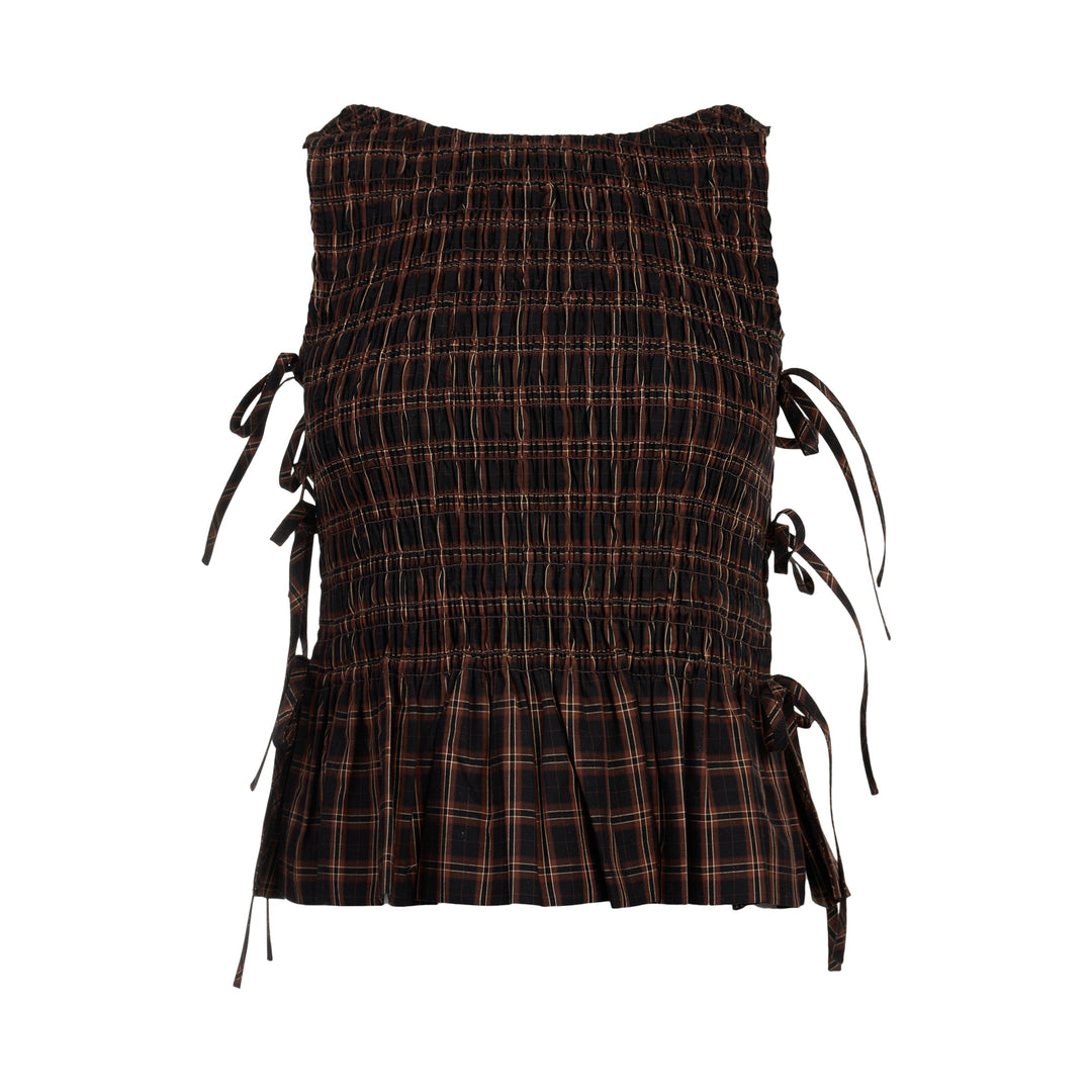 Ganni Check Smocked Tie Blouse in dark yarn-dyed plaid with all-over shirring, adjustable side tie bows, and a pleated peplum hem, shown flat on a white background