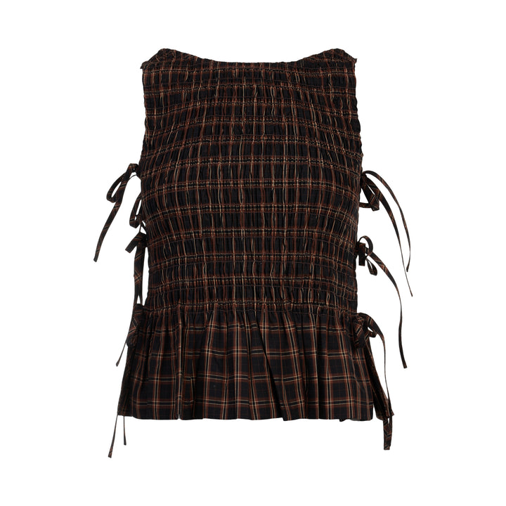 Ganni Check Smocked Tie Blouse in dark yarn-dyed plaid with all-over shirring, adjustable side tie bows, and a pleated peplum hem, shown flat on a white background