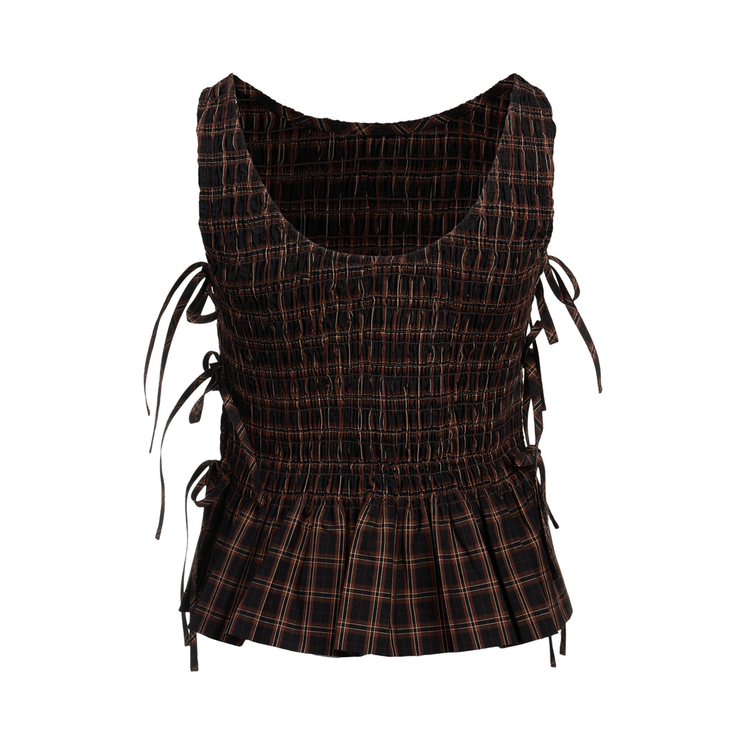 Ganni Check Smocked Tie Blouse in dark yarn-dyed plaid with all-over shirring, adjustable side tie bows, and a pleated peplum hem, shown flat on a white background