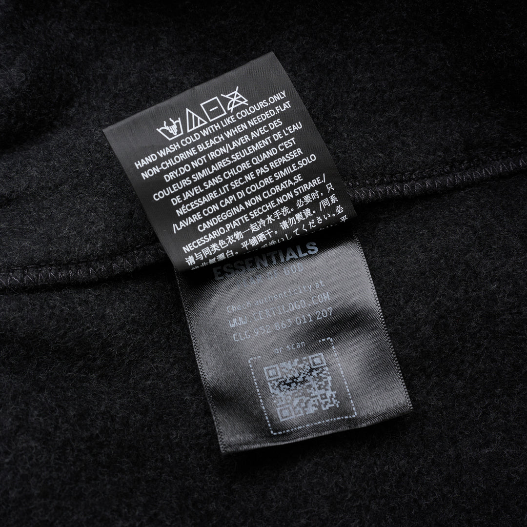 Fear of God Essentials Classic Fleece Sweatpants in dark charcoal with cream drawstring waistband and elasticated ribbed cuffs, flat lay product shot