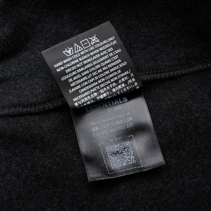 Fear of God Essentials Classic Fleece Sweatpants in dark charcoal with cream drawstring waistband and elasticated ribbed cuffs, flat lay product shot