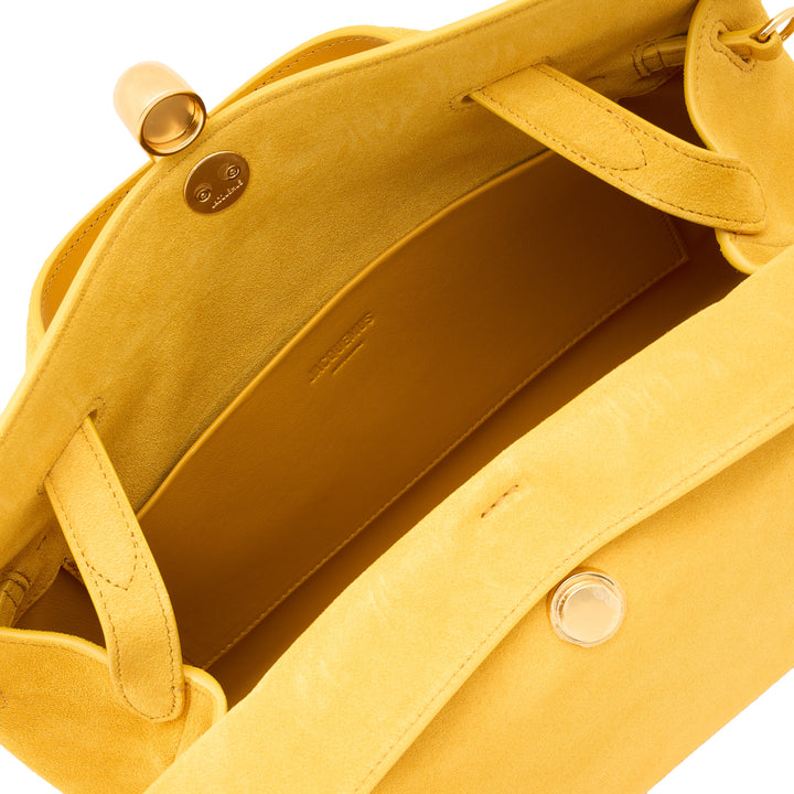 Jacquemus Le Valerie structured tote bag in mustard yellow suede with gold-tone toggle clasp, dual top handles, and adjustable crossbody strap on white background - view 4