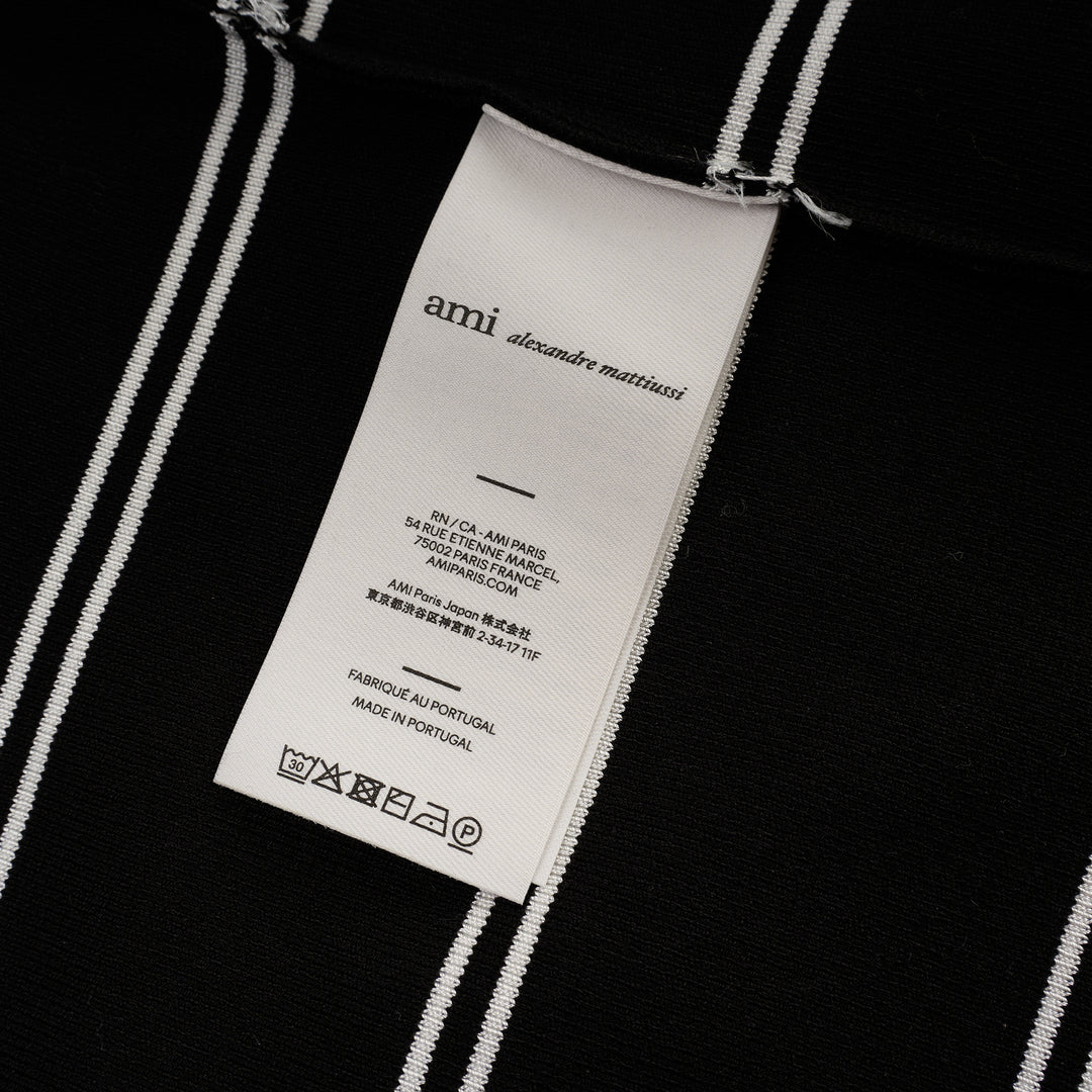 AMI Alexandre Mattiussi Long Sleeve Striped Polo in black with white horizontal stripes, featuring a spread collar, half-zip placket with heart logo pull, and ribbed cuffs - view 3