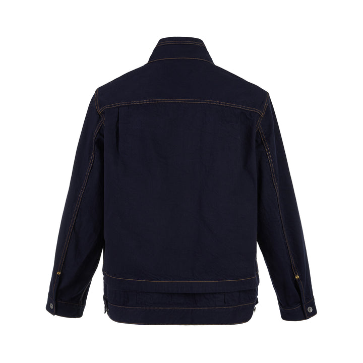 sacai indigo denim trucker jacket with contrast topstitching, pleated front panels, button-flap chest pockets and a layered hem, shown from the front - view 2