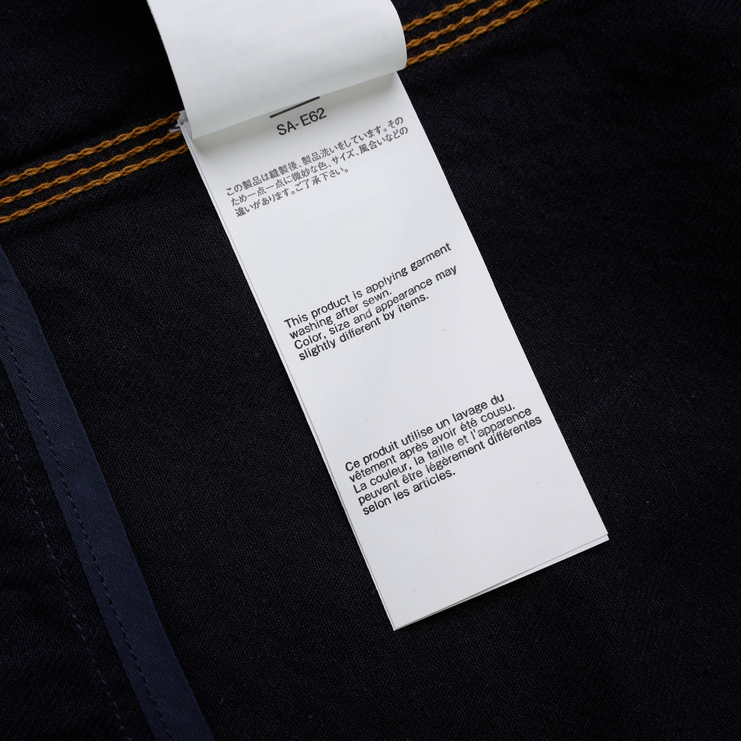 sacai indigo denim trucker jacket with contrast topstitching, pleated front panels, button-flap chest pockets and a layered hem, shown from the front - view 6