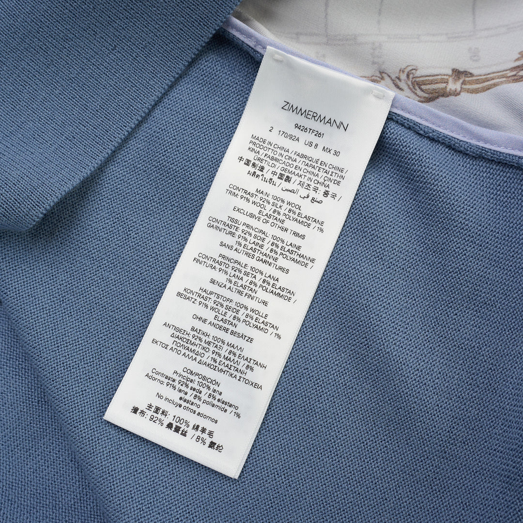 Zimmermann Valiant long sleeve polo with a silk front panel printed with a vintage world map and aeroplanes, framed by blue knit collar, sleeves, and hem - view 3