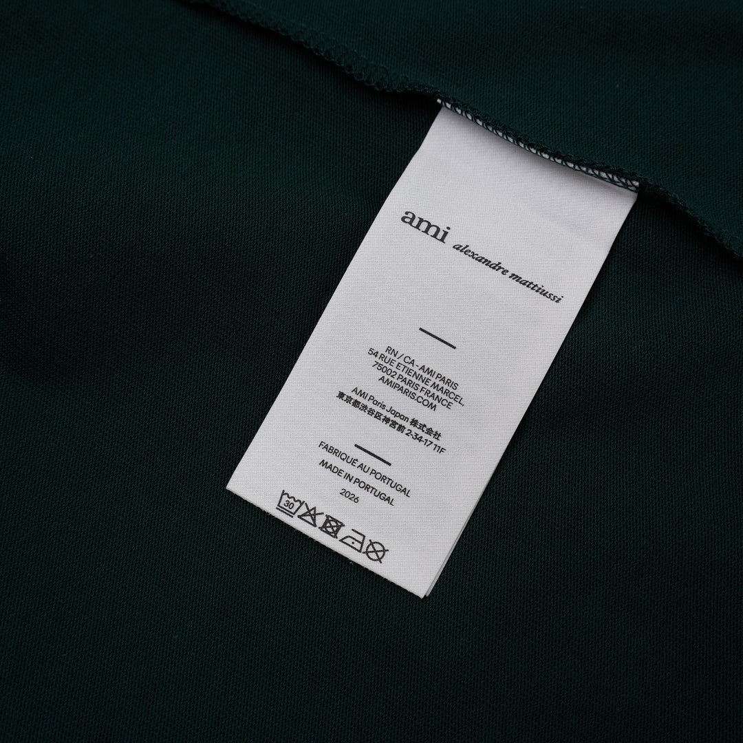 AMI Paris oversized t-shirt in dark green with cream contrast sleeves and collar, featuring white felt AMI PARIS lettering across the chest - view 3