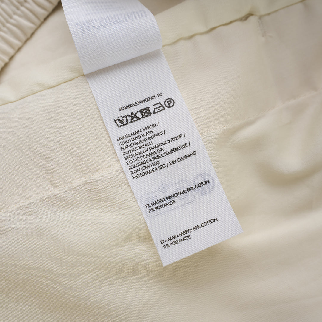 Jacquemus Le Short Pyjama cream pleated shorts with elasticated waistband, button closure and side piping, shown from the front - view 3