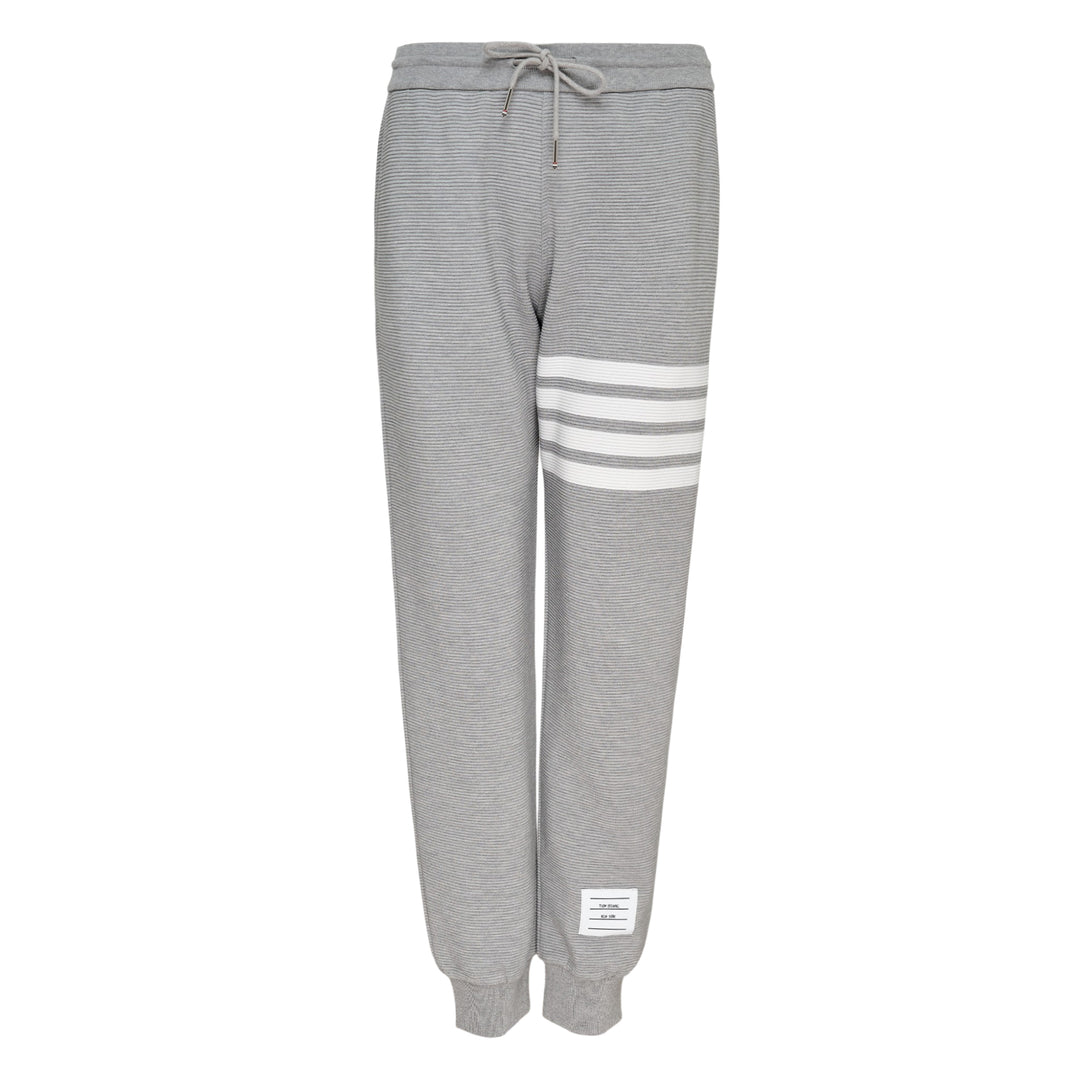 Thom Browne 4 Bar Cotton Sweatpants in heather grey with white four-bar stripe detailing on the thigh, drawstring waist and ribbed ankle cuffs