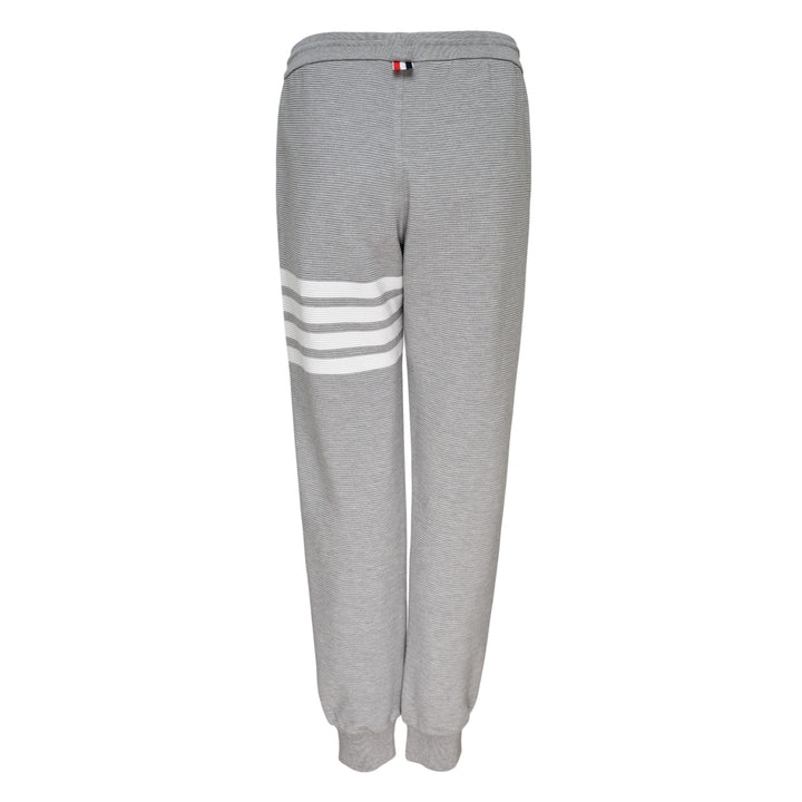 Thom Browne 4 Bar Cotton Sweatpants in heather grey with white four-bar stripe detailing on the thigh, drawstring waist and ribbed ankle cuffs