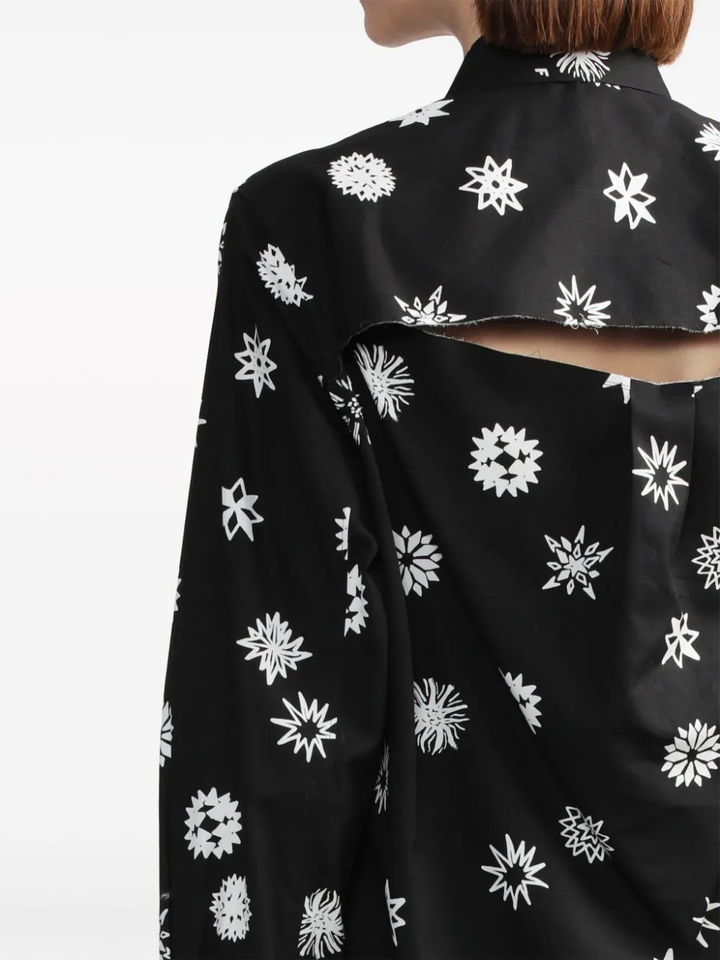 Comme des Garçons BLACK Filip Pagowski Print Blouse in black with allover white snowflake and floral graphic motifs, long sleeves and point collar, flat lay view