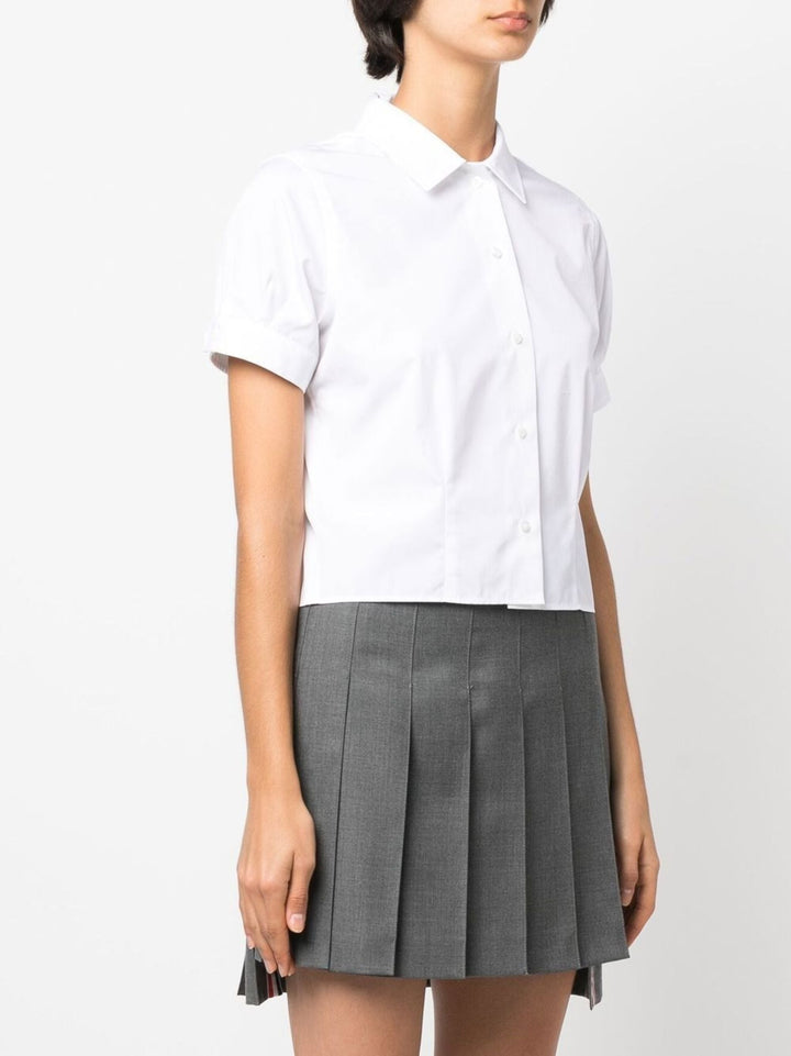 Thom Browne white cropped short sleeve button-front shirt with point collar and cuffed sleeves on a plain white background