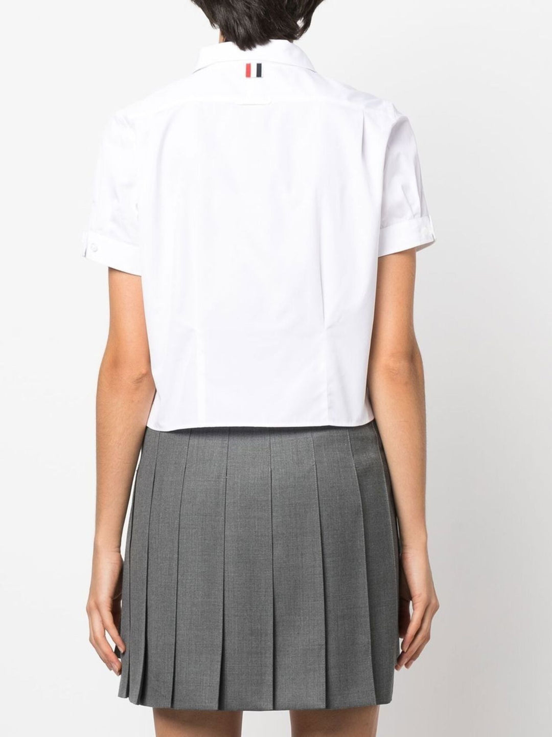 Thom Browne white cropped short sleeve button-front shirt with point collar and cuffed sleeves on a plain white background