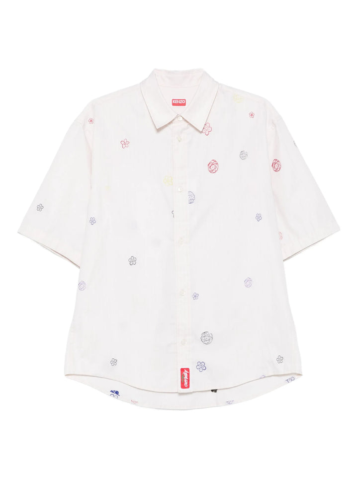 Kenzo Futura Short Sleeve Shirt in off-white with scattered multicolour embroidered flower and globe motifs, featuring a point collar, button-through placket, and curved hem with a woven script logo patch