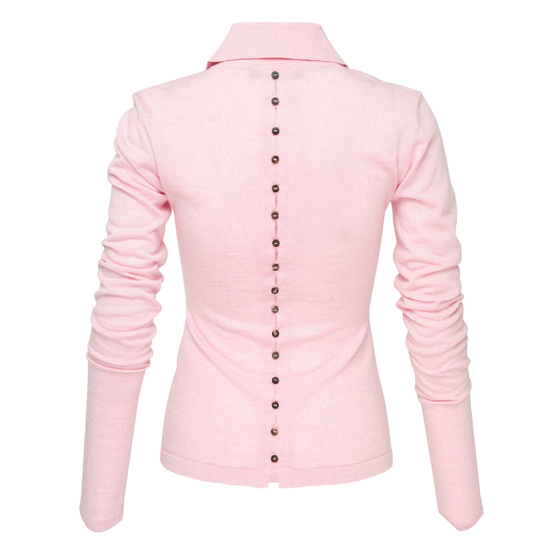 Jacquemus Le Polo Merino long-sleeve knit polo in blush pink with dark snap-button placket, ruched sleeves, and snap-button cuffs, displayed on a flat lay against a white background - view 2
