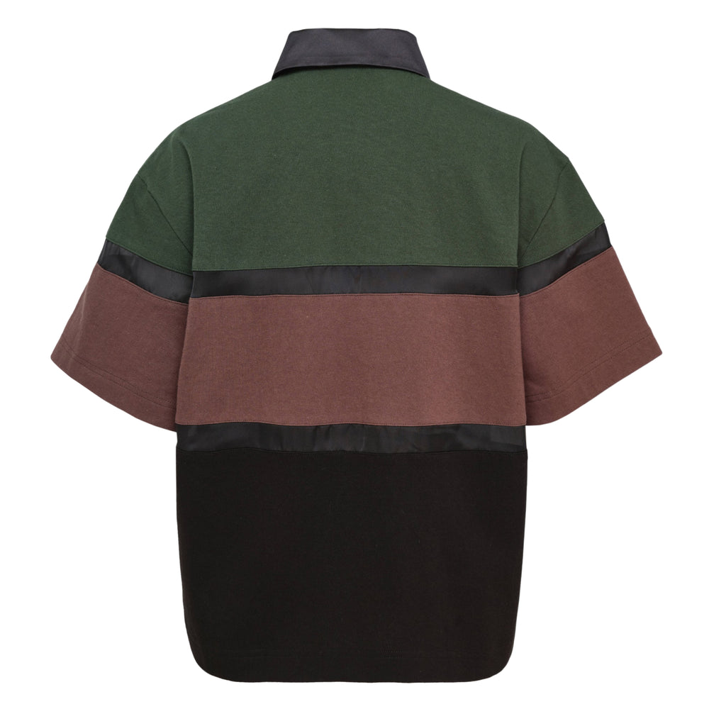 sacai color block short sleeve shirt with forest green, dusty mauve, and black panels separated by horizontal satin ribbon trim, featuring a concealed button placket and satin-trimmed point collar