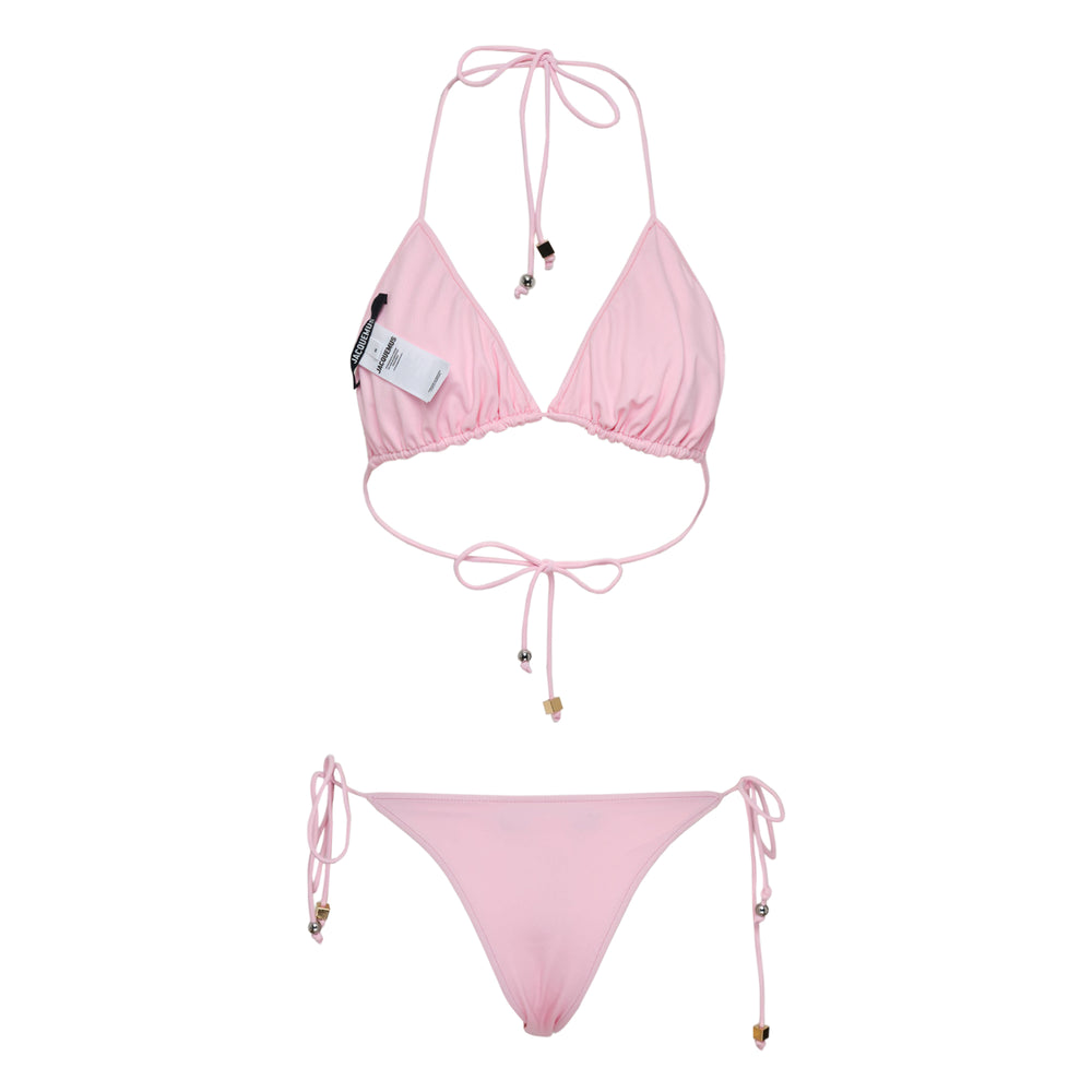 Jacquemus navy and white polka dot triangle bikini set with halter neck tie top and adjustable side-tie bottoms, featuring gold-tone hardware charms
