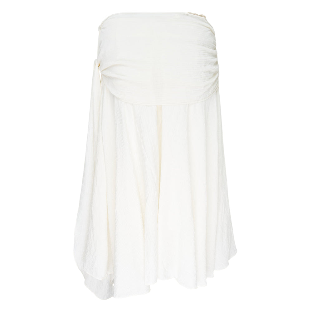 Glowny Sunset Drape Midi Skirt in blush pink with gathered ruched waistband, knotted side tie, and asymmetric handkerchief hem